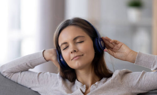 Relaxed calm teen girl wearing headphones listening to soothing music