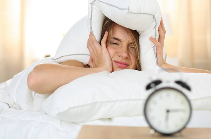 Young Woman Trying to Ignore Alarm